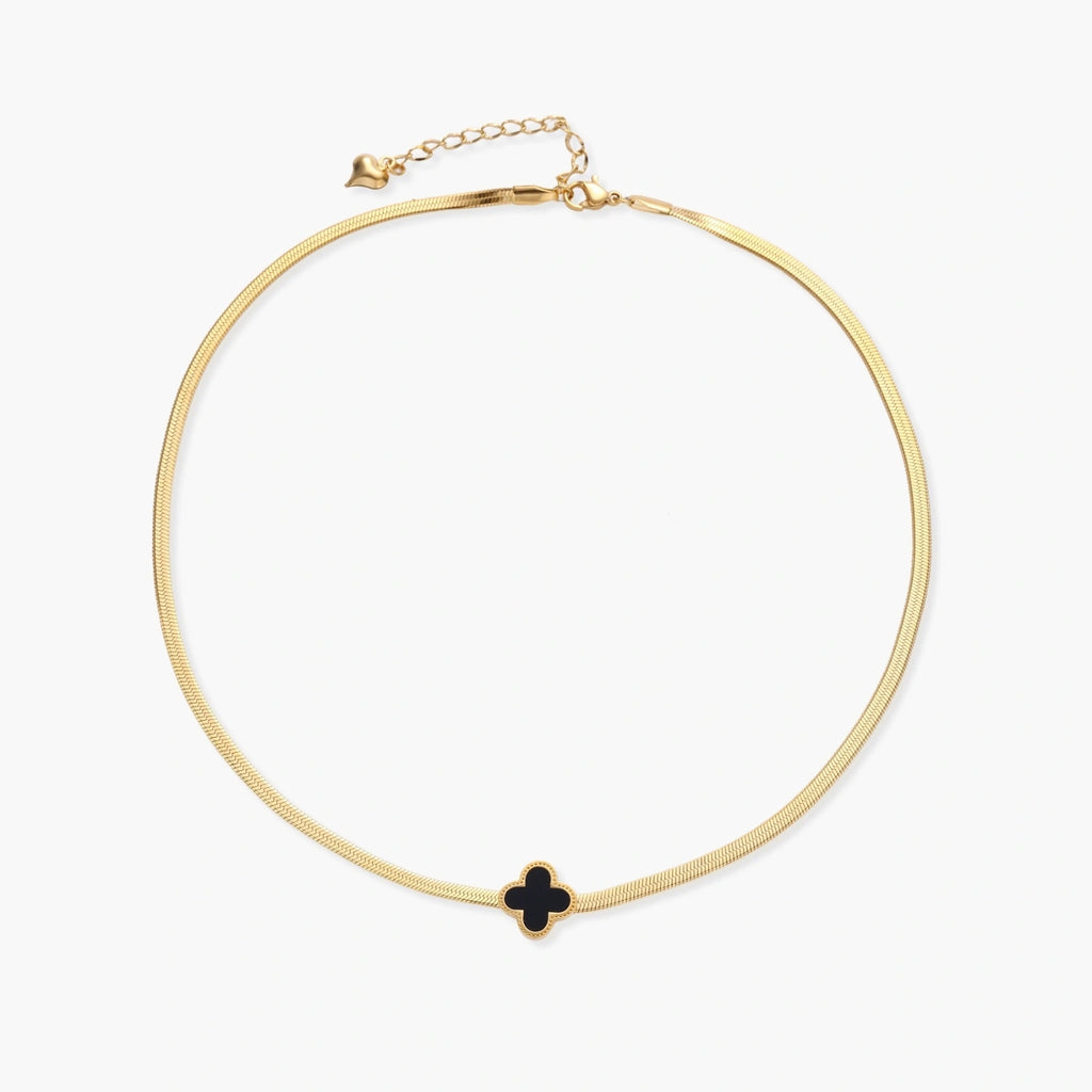 Dainty 18K gold-plated herringbone chain necklace with black enamel quatrefoil clover pendant on white background