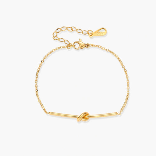 Delicate gold chain bracelet featuring a minimalist bar and a central knot detail, exuding elegance and sophistication.