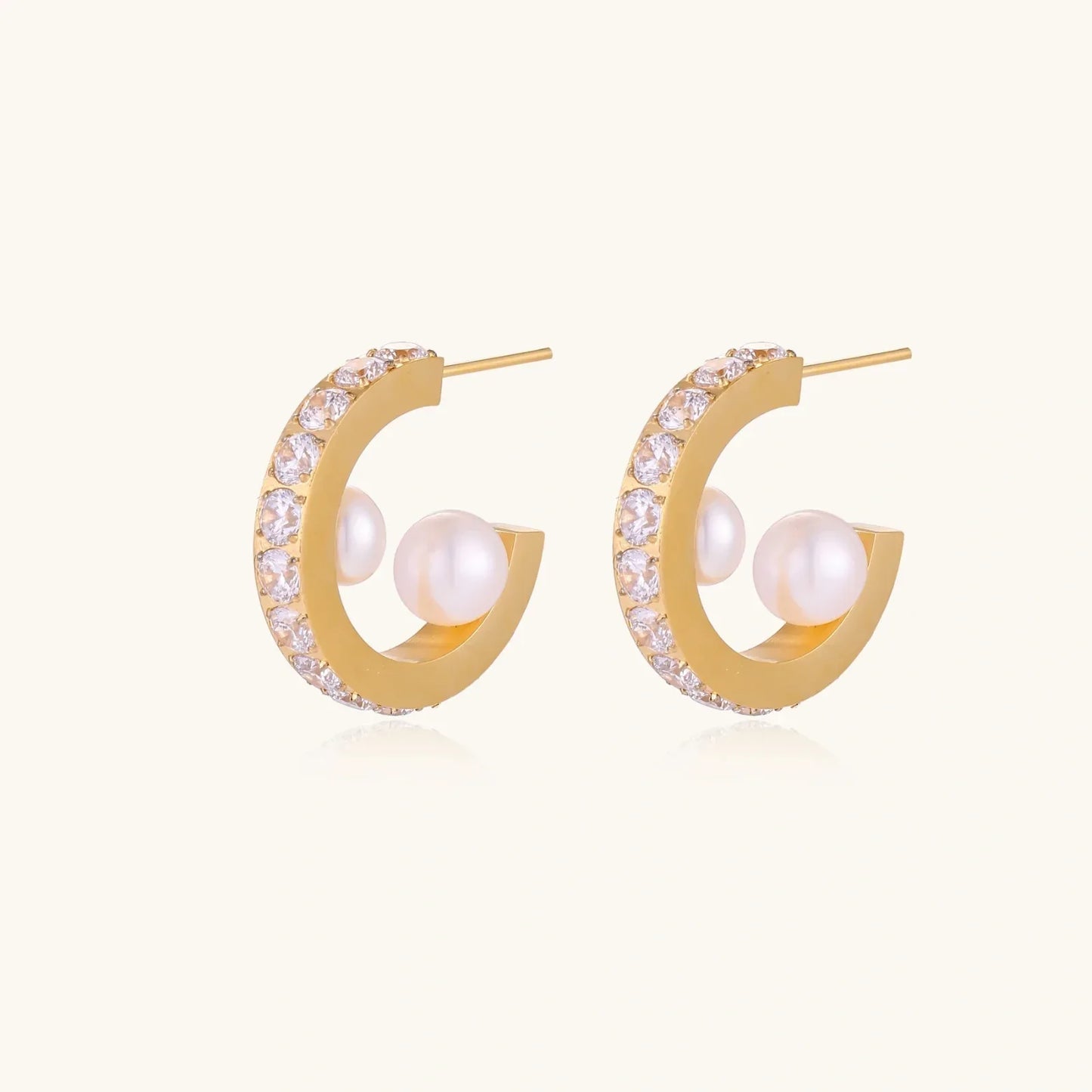 Gold pavé hoop earrings with two freshwater pearls nestled inside the curved design, featuring crystal-studded outer edge.