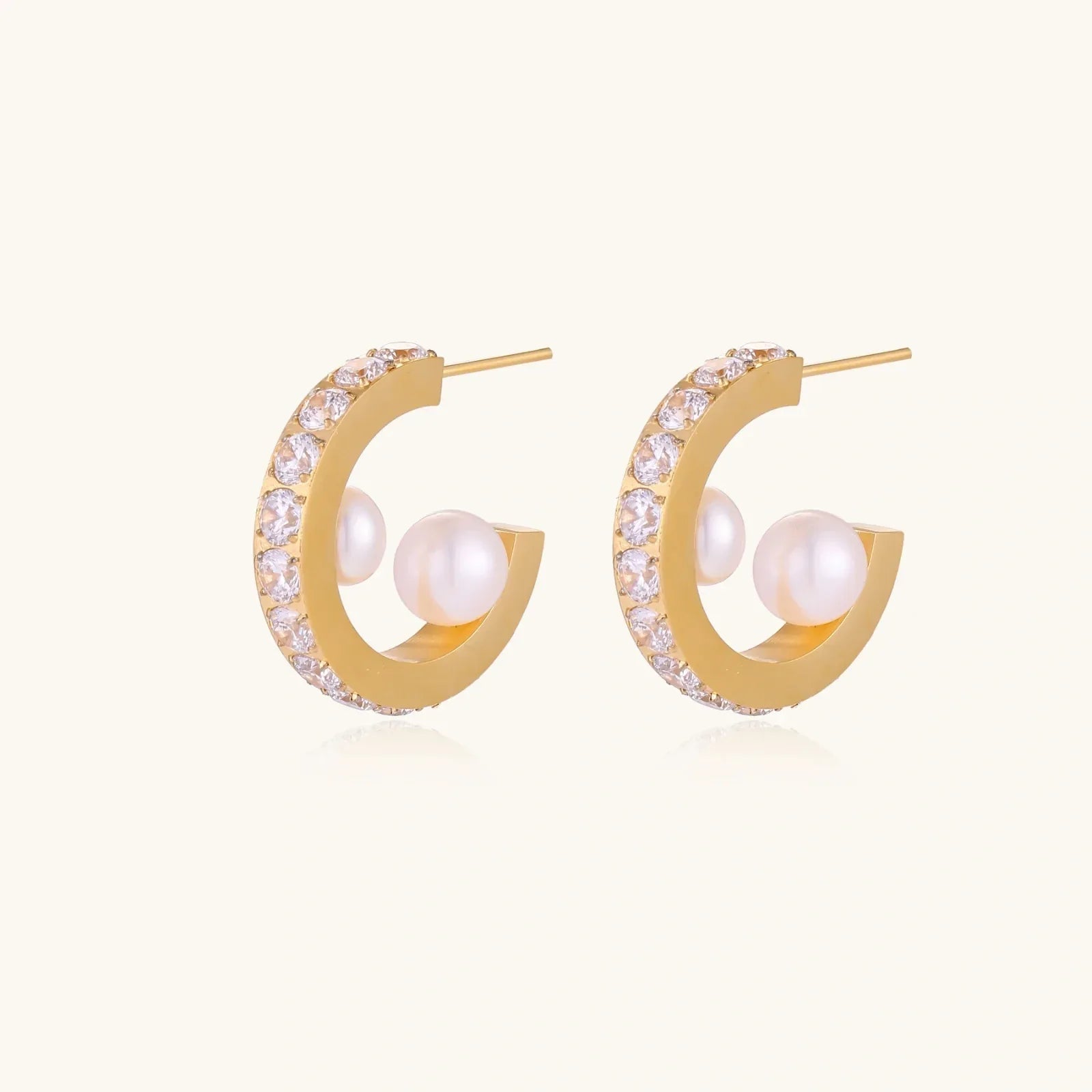 Gold pavé hoop earrings with two freshwater pearls nestled inside the curved design, featuring crystal-studded outer edge.
