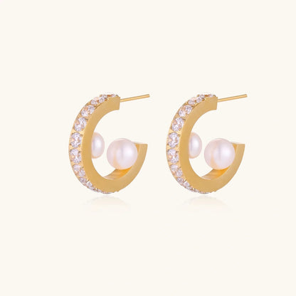 Gold pavé hoop earrings with two freshwater pearls nestled inside the curved design, featuring crystal-studded outer edge.
