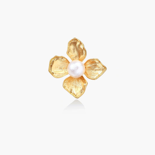 Gold-plated flower ring with textured petals and white cotton pearl center on cream background