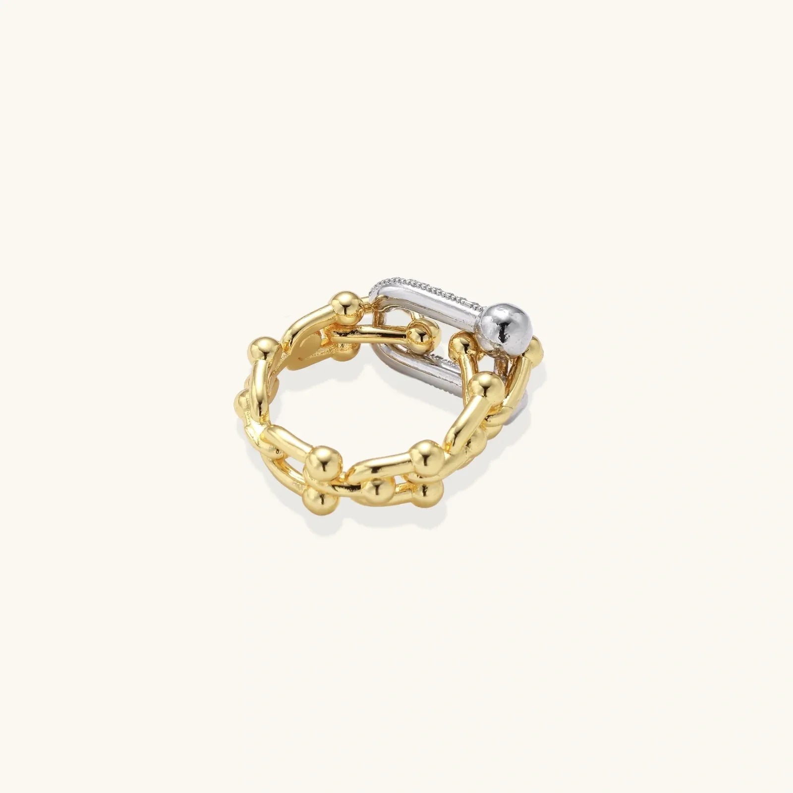 Triple-band gold ring with spherical bead chains and two crystal-pavé bars on cream background