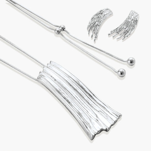 Layered metallic wing-shaped pendant and matching earrings with feathered texture in silver and gold finishes