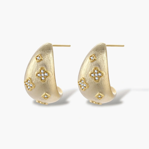 Curved gold-plated hoop earrings with four-leaf clover and diamond-shaped crystal details on white background