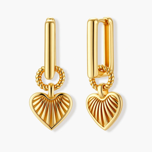 Gold-toned huggie earrings featuring a textured heart pendant with a radiant sunburst design.