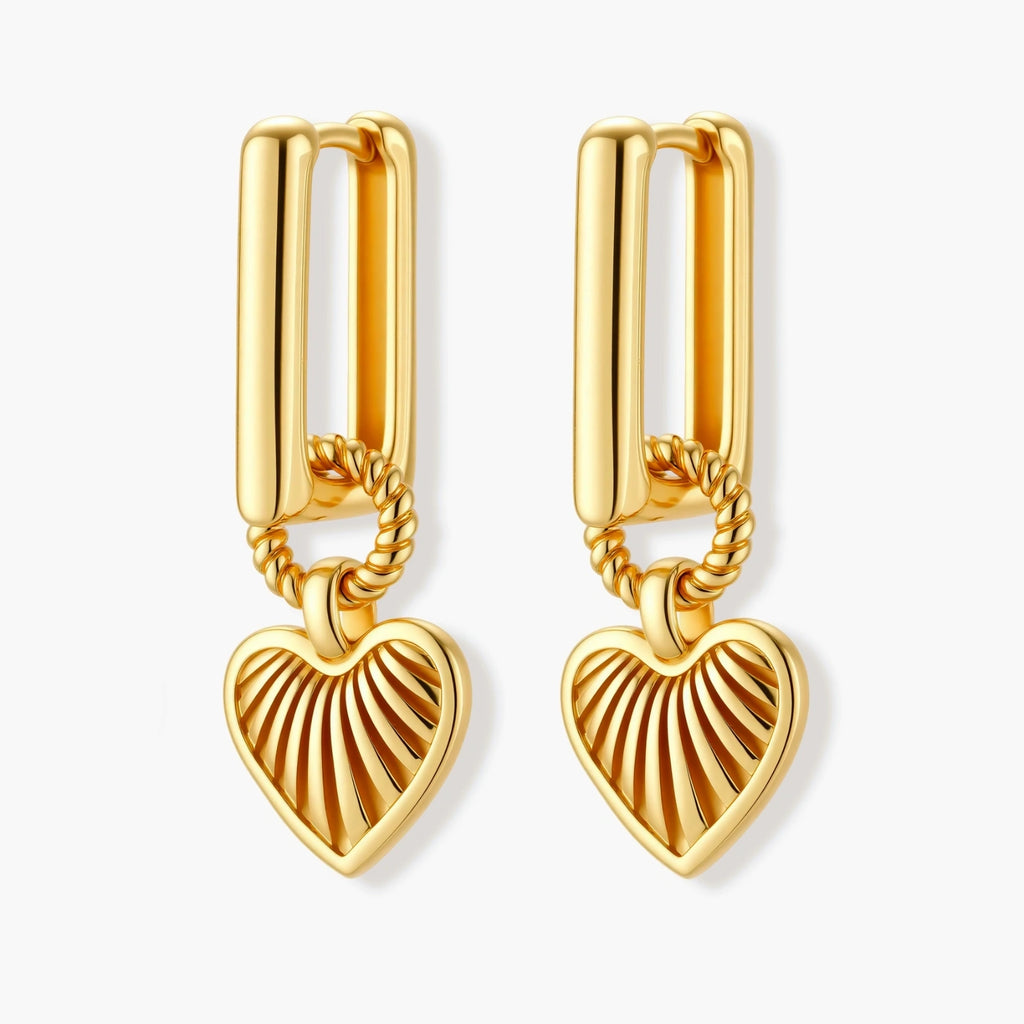 Gold-plated huggie earrings with textured heart charms featuring radiating sunburst patterns on white background.