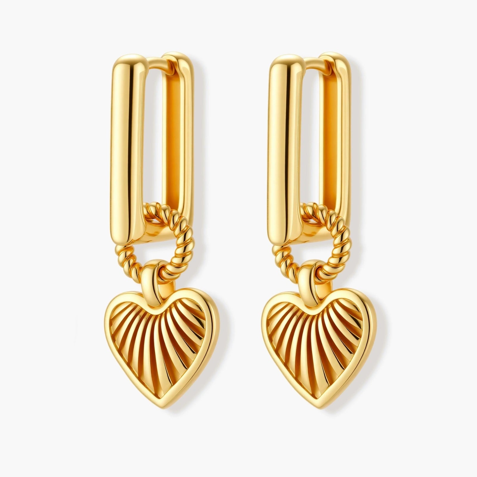 Gold-plated huggie earrings with textured heart charms featuring radiating sunburst patterns on white background.