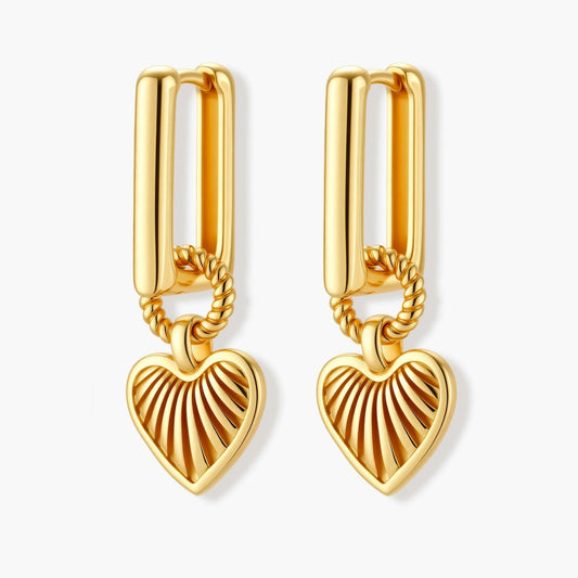 Gold-plated huggie earrings with textured heart charms featuring radiating sunburst patterns on white background.