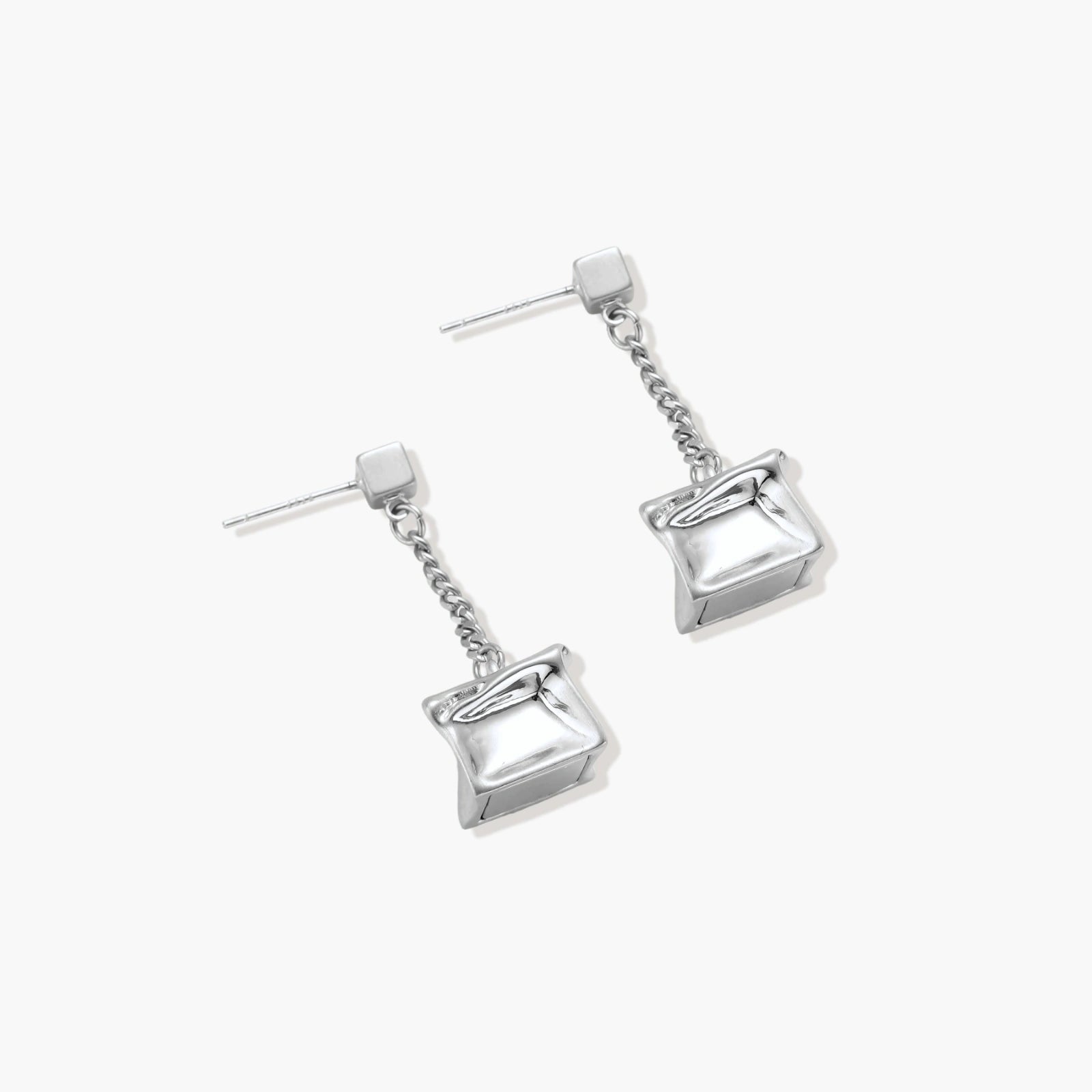 Modern silver dangle earrings with geometric cube pendants and chain design on minimalist background.