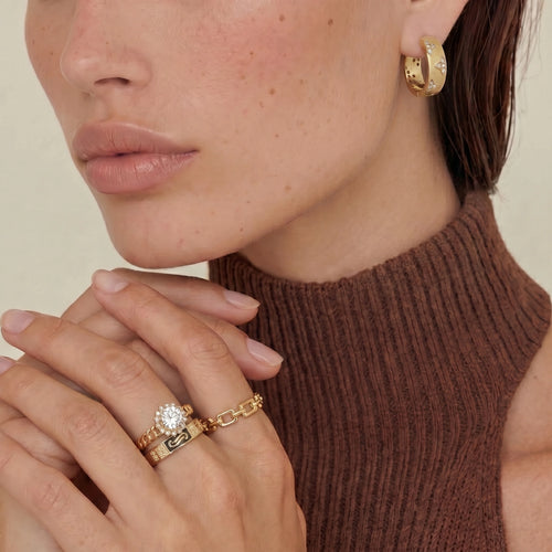 Two elegant rings worn together: a haloed cubic zirconia ring and a chunky U-link chain band, showcasing adjustable style.