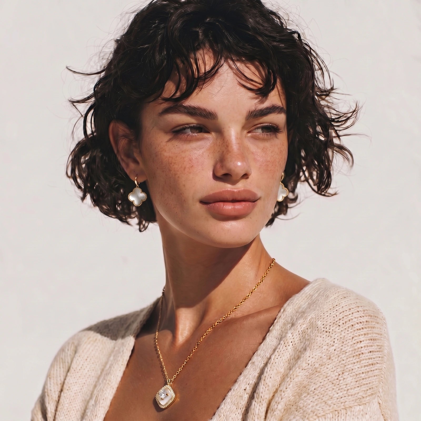 Cushion-shaped pendant on a slim chain, featuring a clear stone above a cream inlay, elegantly showcased.