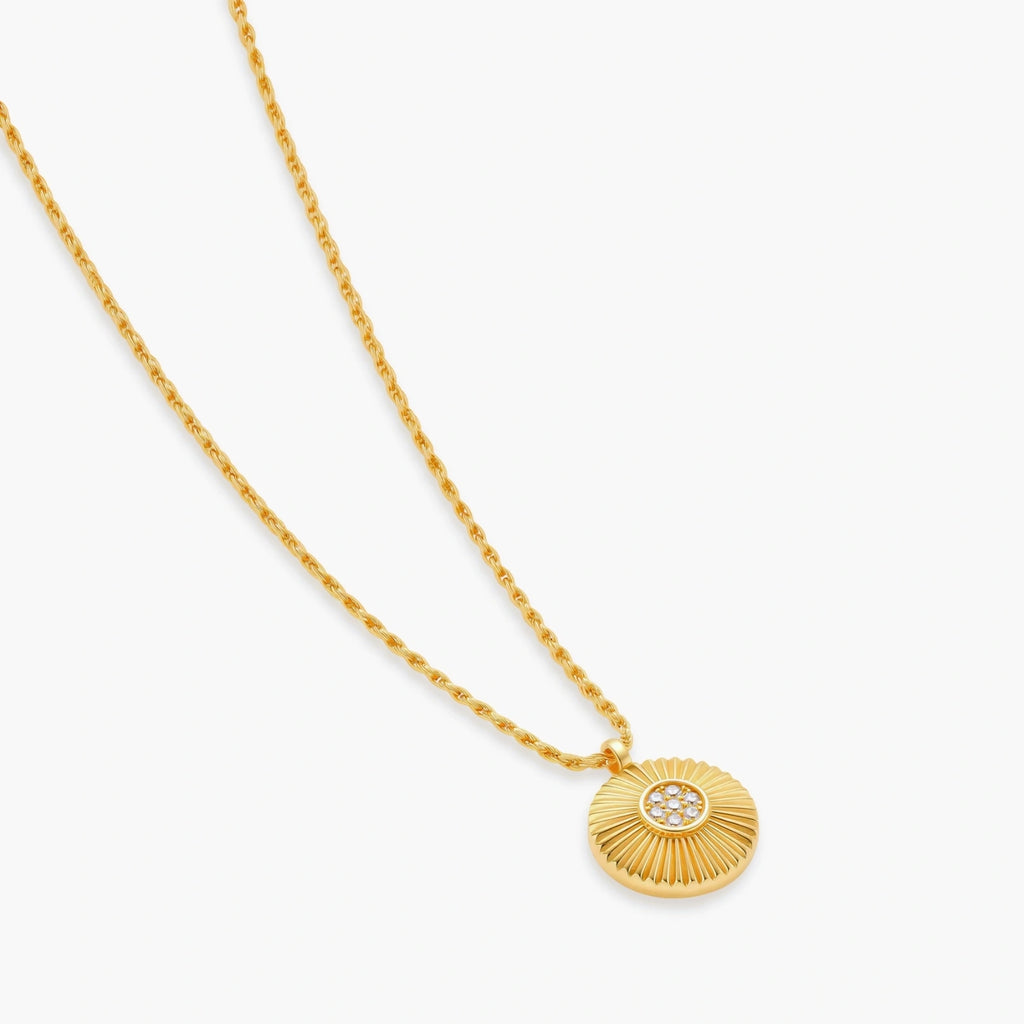 Gold-plated sterling silver necklace with sunburst pendant featuring radiating lines and cubic zirconia center stones
