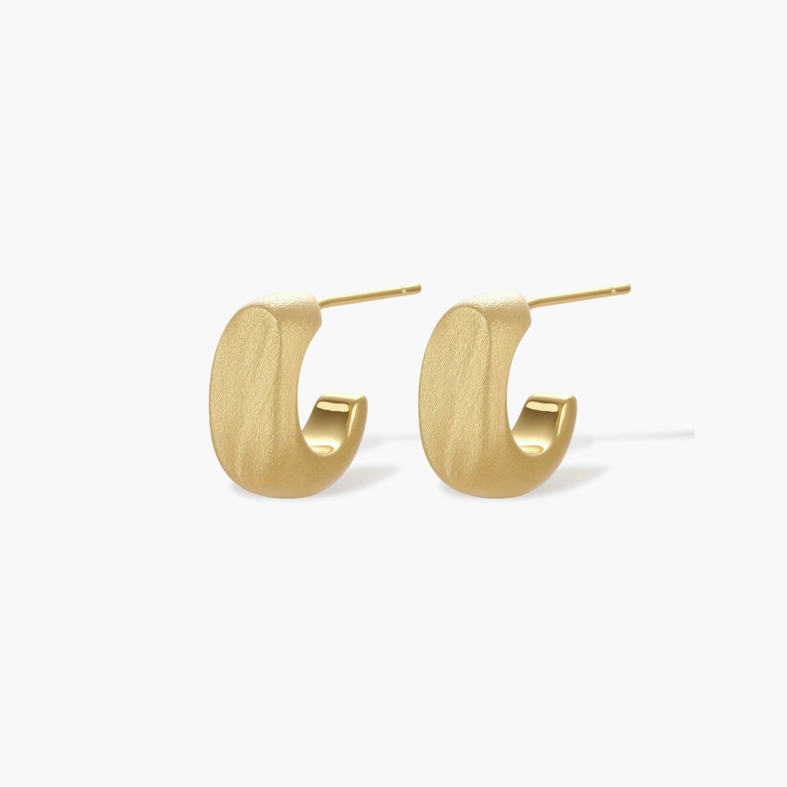 Small gold huggie earrings with matte finish, 14mm diameter, shown against cream background for everyday elegance.