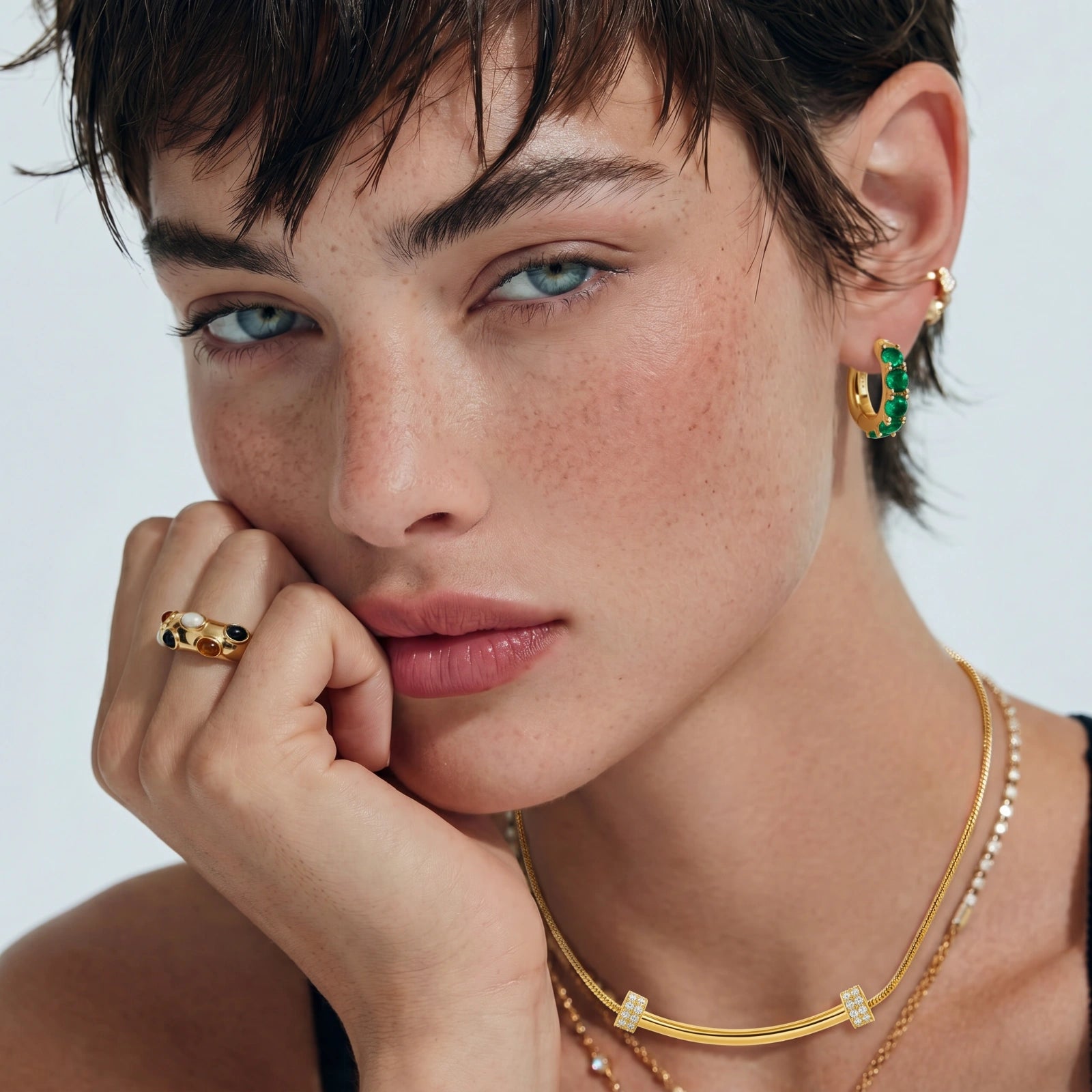 Model showcasing the Cosmic Bubble Ring, a domed gold band adorned with six vibrant cabochons, styled elegantly with minimal makeup.