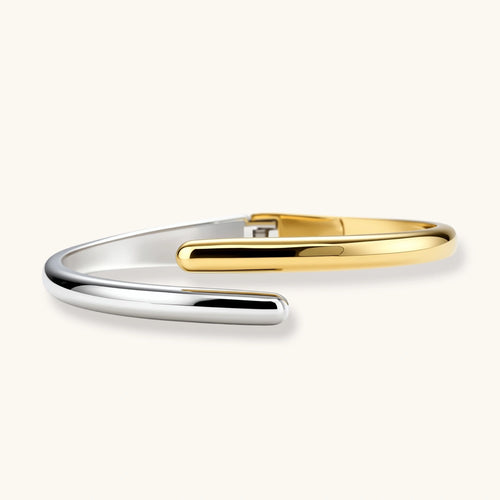 Polished dual-tone cuff bracelet featuring overlapping silver and gold bands with rounded tapered ends.