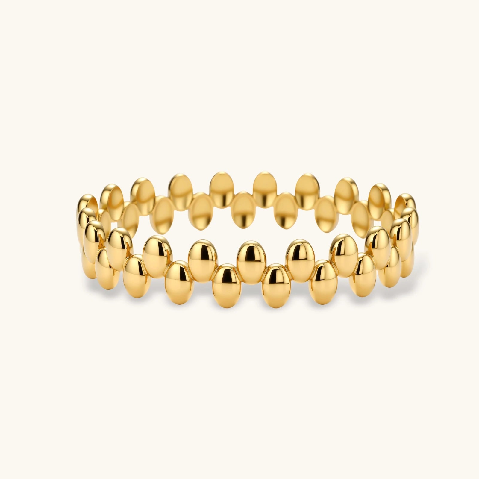Sculptural double-row bracelet featuring glossy gold beads and a radiant finish.