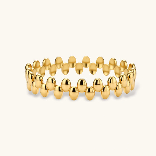 Sculptural double-row bracelet featuring glossy gold beads and a radiant finish.