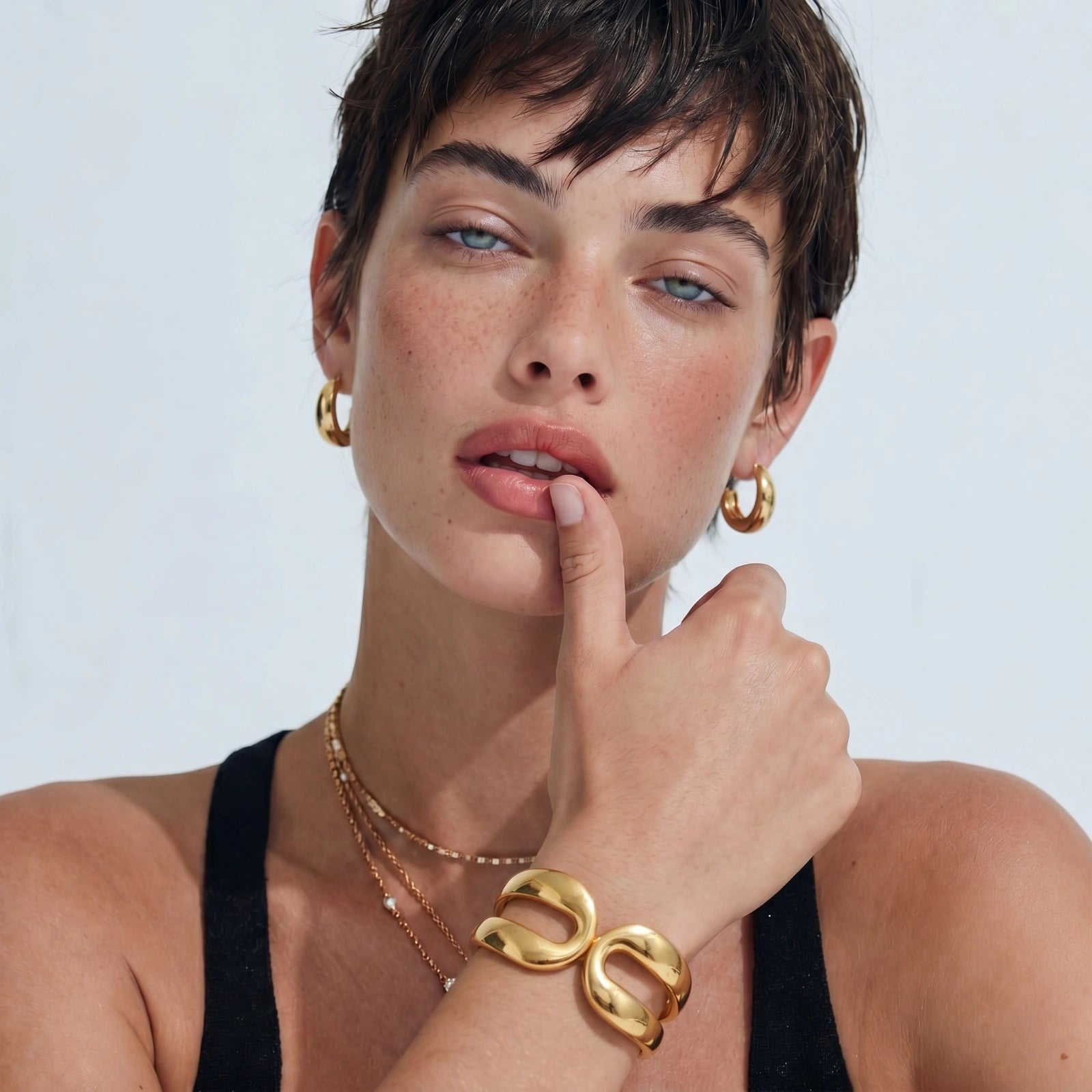Polished cuff bracelet worn on a model, featuring an elegant sculpted double-loop design.