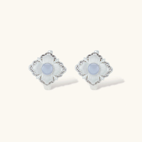 Silver-plated flower earrings with blue zirconia centers, featuring one stud and one huggie hoop in mismatched pair style.