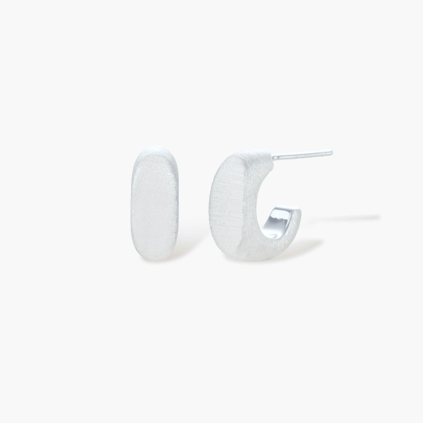 Pair of small silver-plated huggie hoop earrings with clean minimal design on neutral background.