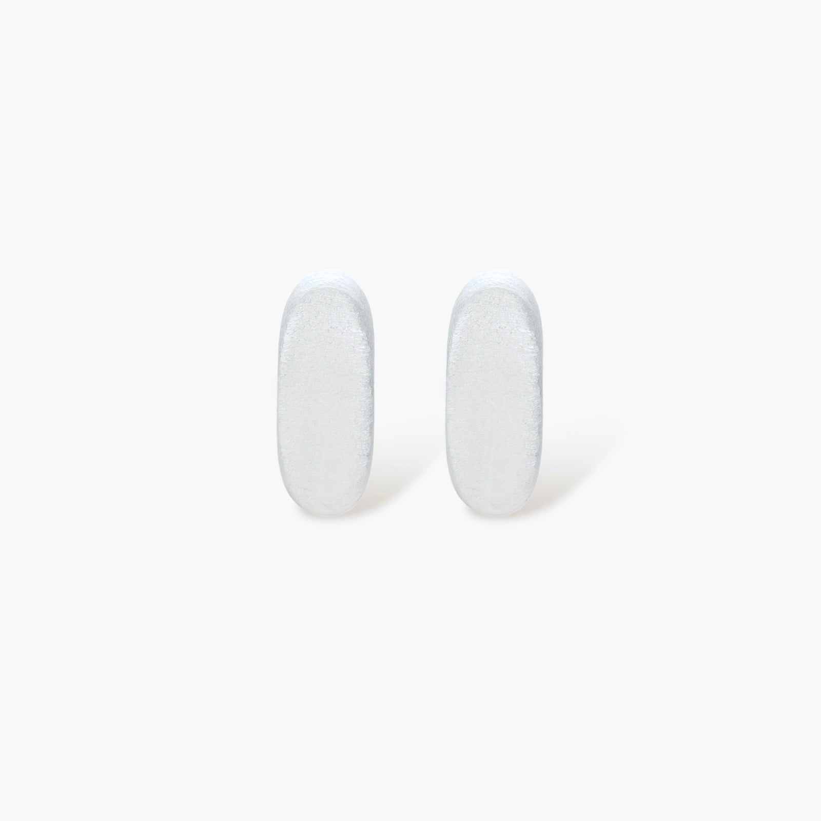 Pair of small silver-plated huggie hoop earrings with clean minimal design on neutral background.