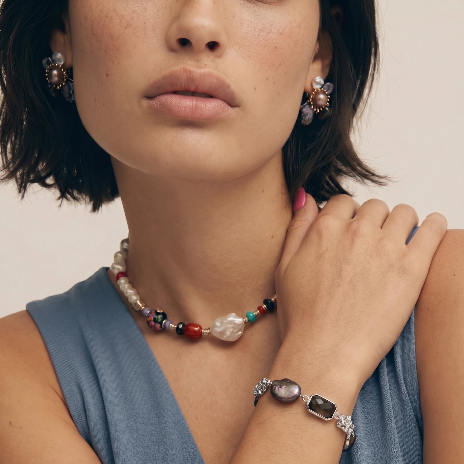 Chunky chain bracelet showcasing a baroque pearl, smoky quartz rounds, and a deep black faceted stone.