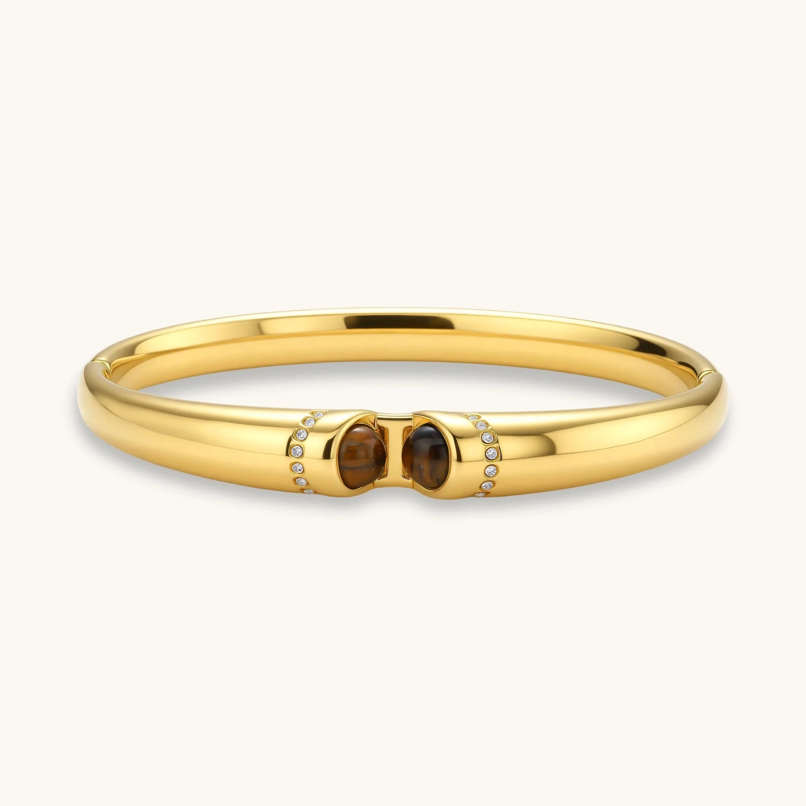 Polished gold bangle featuring two oval tiger's eye stones and pavé diamond accents for an elegant statement.