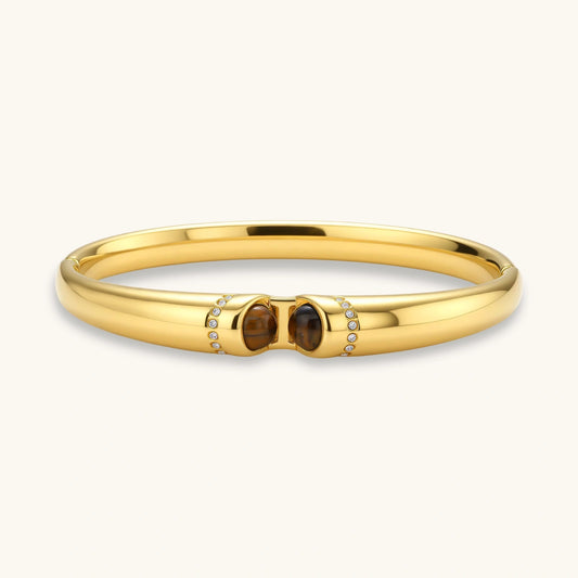Polished gold bangle featuring two oval tiger's eye stones and pavé diamond accents for an elegant statement.