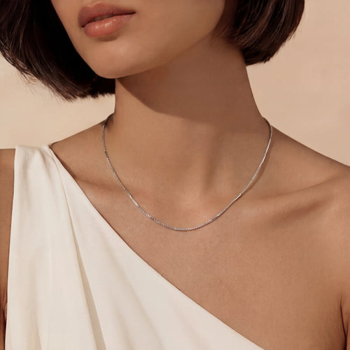 Slender chain necklace elegantly worn, showcasing a polished surface and refined design, perfect for sophisticated styling.