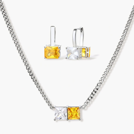 Elegant silver curb-chain necklace and matching huggie earrings featuring clear and warm yellow square zirconia stones.