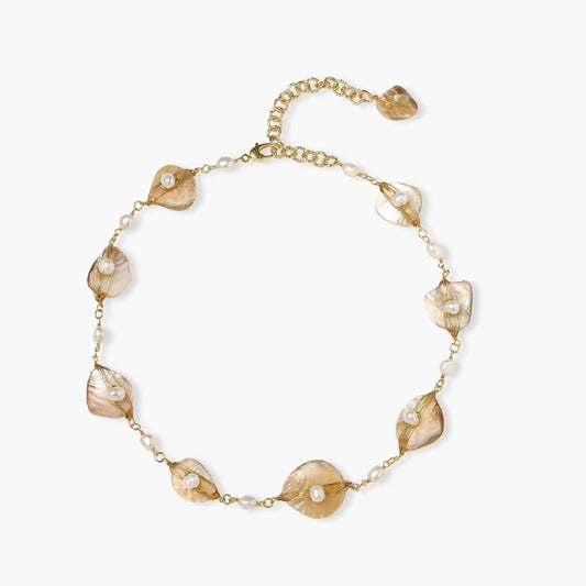 Gold-plated necklace featuring wire-wrapped shell fragments and freshwater pearls, showcasing coastal elegance.