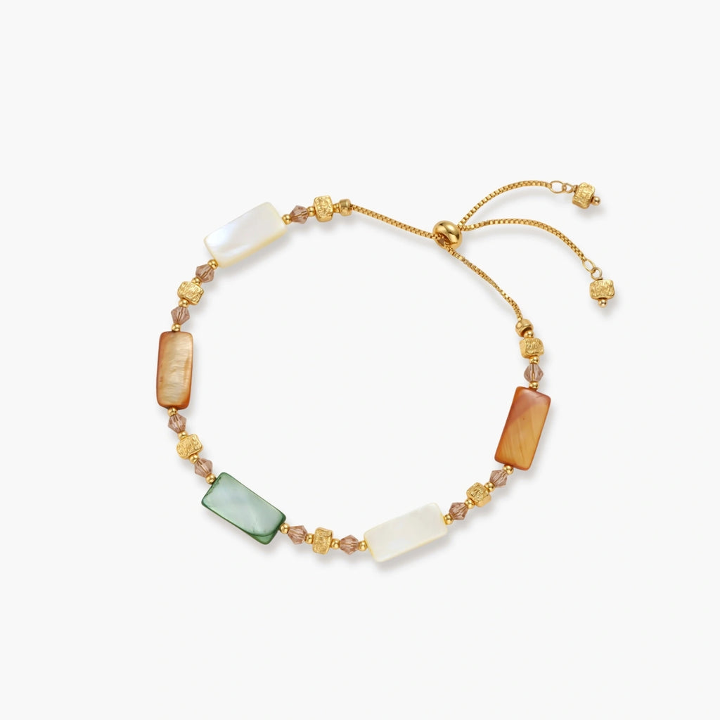 Adjustable gold-plated bracelet featuring rectangular shell beads in green, orange, and white tones on cream background.