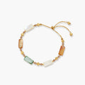 Adjustable gold-plated bracelet featuring rectangular shell beads in green, orange, and white tones on cream background.