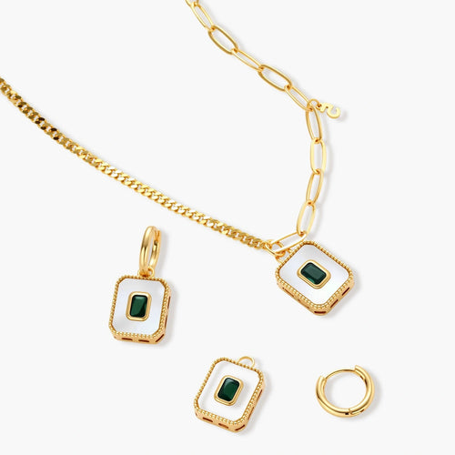 Gold-plated jewelry set with white enamel square pendants and emerald CZ stones on cream background.