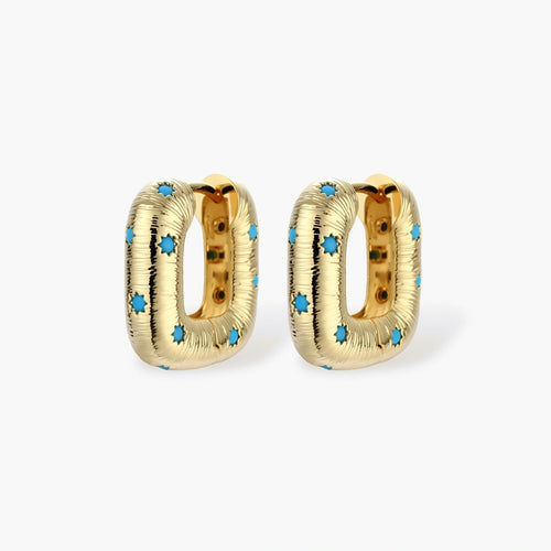 Gold-plated huggie hoop earrings with blue star inlays and textured surface, shown against white background.