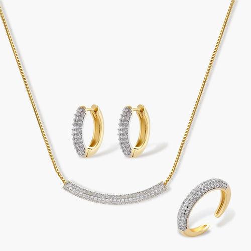 Gold-plated crescent jewellery set featuring a curved pavé bar necklace, huggie earrings, and an adjustable ring.