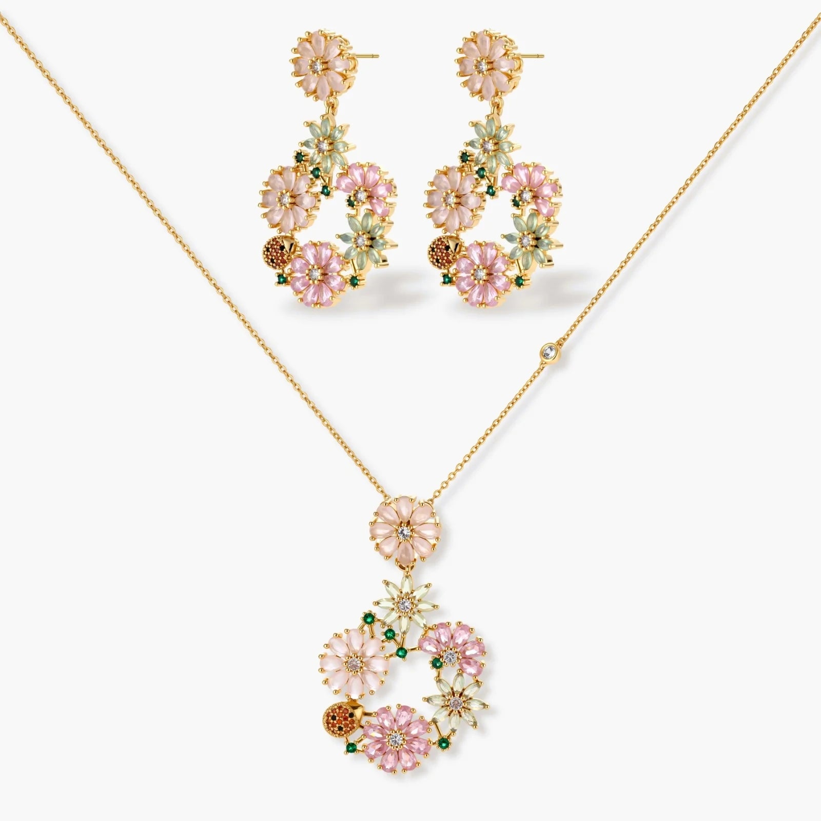 Floral jewellery set featuring pink, peach, and green motifs in a gold tone, including matching earrings and pendant.