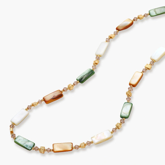 Adjustable gold-plated necklace with natural shell beads in green, amber, and cream tones on neutral background.