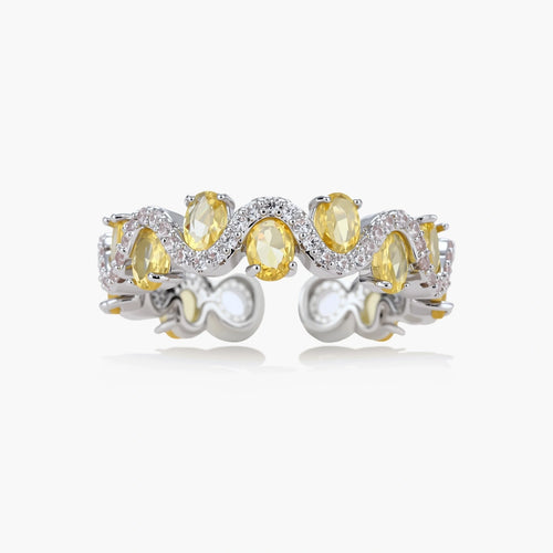 Close-up of an adjustable ring with golden zirconia stones in oval settings and clear accent stones on white gold-plated band.