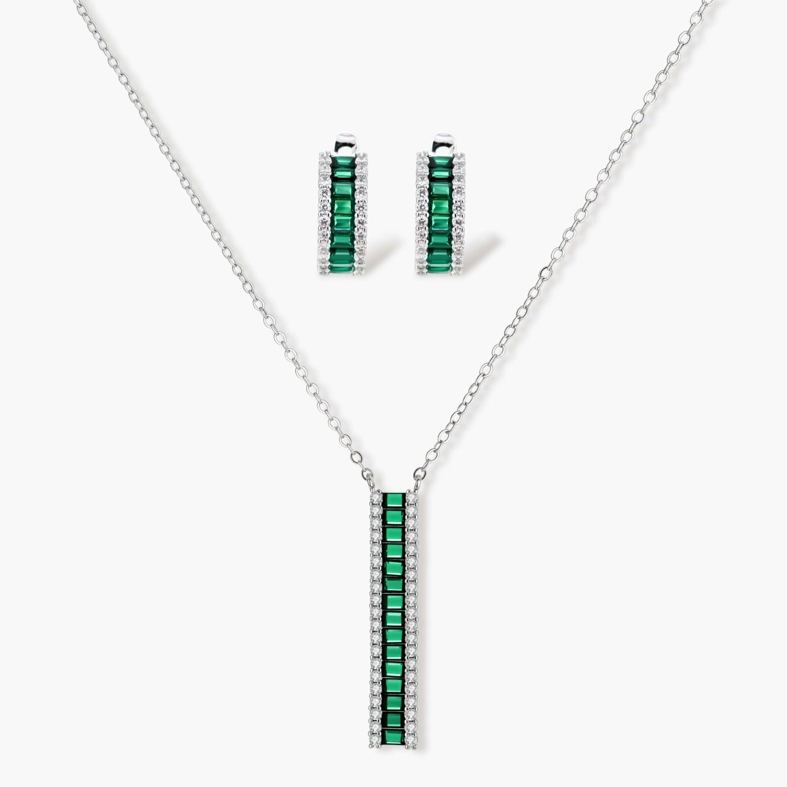 Elegant jewellery set featuring a necklace with green baguette elements and matching huggie earrings in a refined silver tone.