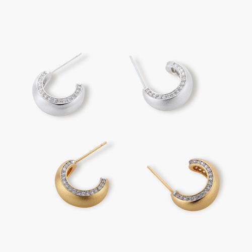 Close-up of small silver-plated hoop earrings with brushed texture and a row of sparkling zircon crystals on white background