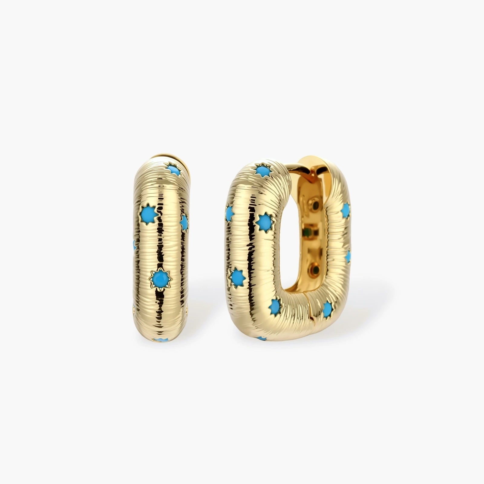 Gold-plated huggie hoop earrings with blue star inlays and textured surface, shown against white background.
