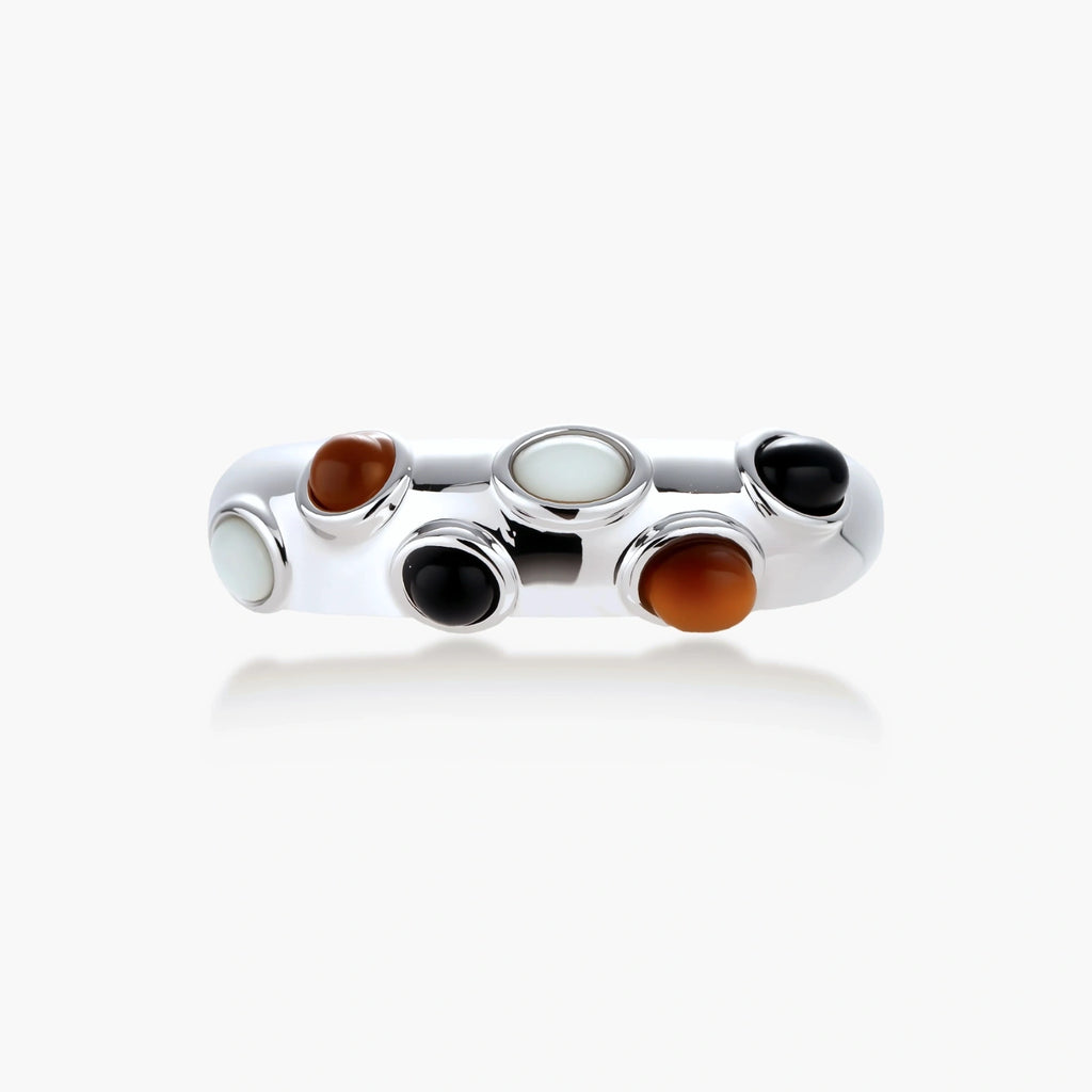 Adjustable platinum-plated ring with multiple oval cabochon stones in black, amber, and white tones on neutral background.