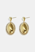 Statement earrings with an oval charm surrounded by stones