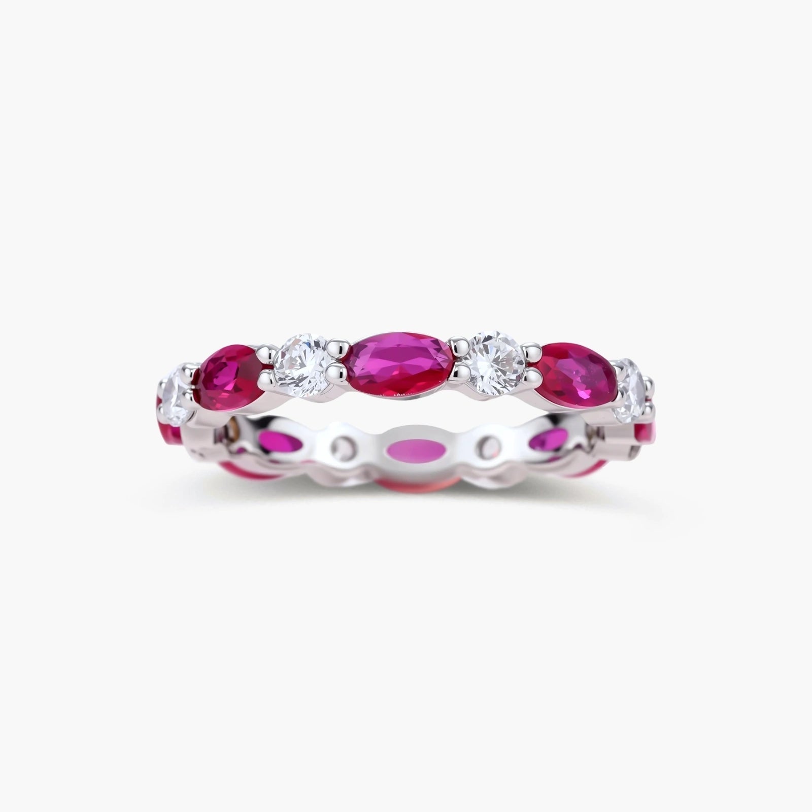 Platinum-plated eternity ring with alternating oval ruby and round clear stones in continuous band setting